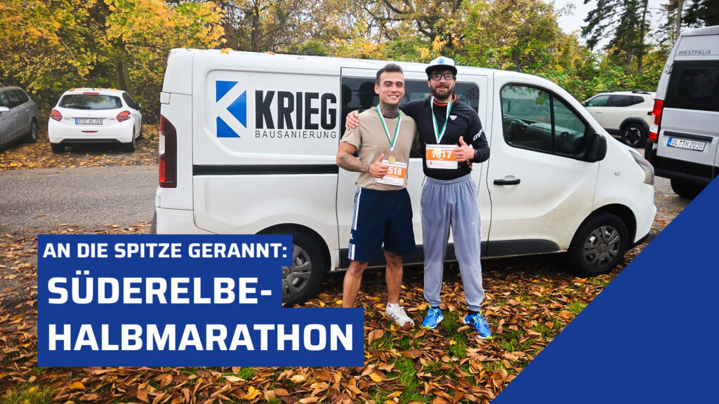 Zwei Läufer posieren stolz nach einem Lauf vor einem weißen Transporter mit dem Logo "Krieg Bausanierung". Der linke Mann trägt ein beiges T-Shirt, dunkelblaue Shorts und die Startnummer 1518. Der rechte Mann trägt ein schwarzes Langarmshirt, eine Kappe und die Startnummer 1517. Sie stehen auf herbstlichem Laub mit Bäumen im Hintergrund.