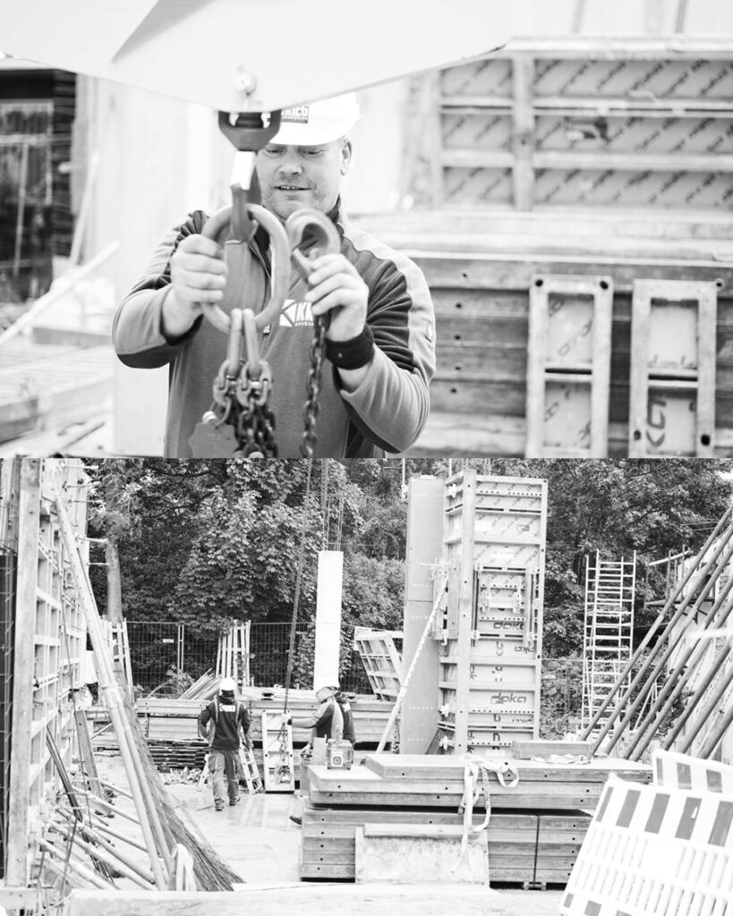 Bauarbeiter bei der Einweisung einer Last am Kranhaken während der Errichtung der großvolumigen Stahlbeton-Produktionshalle.