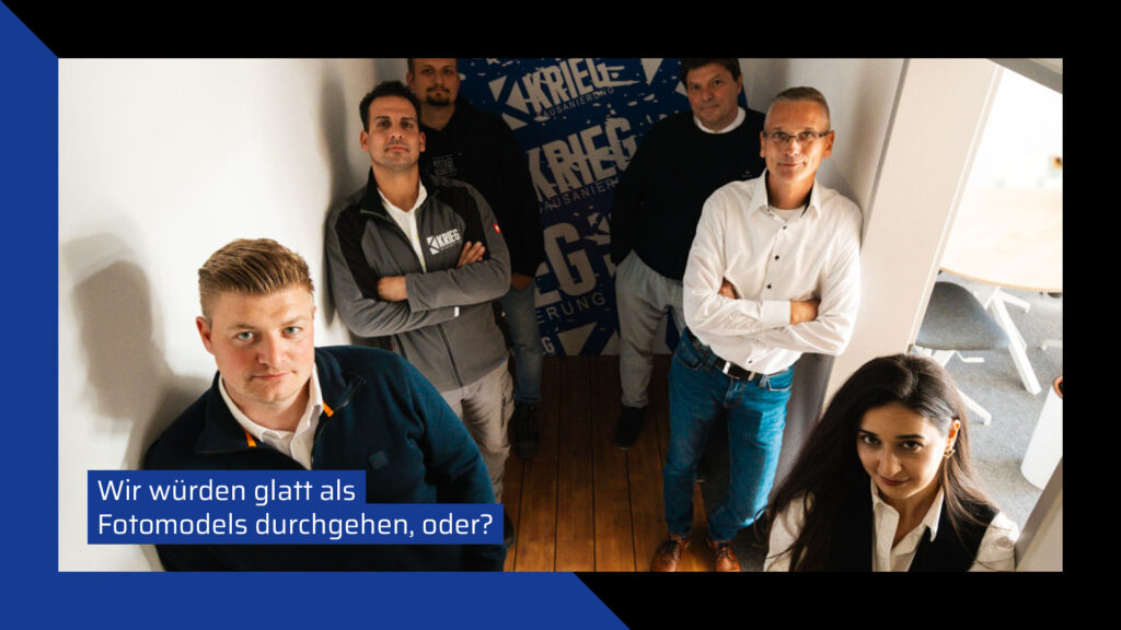 Gruppenbild des Teams von KRIEG Bausanierung in einem modern gestalteten Flur mit Holzboden. Fünf Männer und eine Frau posieren selbstbewusst vor einer Wand mit dem Firmenlogo. Im oberen Bereich ist der Text „Wir würden glatt als Fotomodels durchgehen, oder?“ eingeblendet. Das offizielle Logo der Bausanierung KRIEG befindet sich unten links.