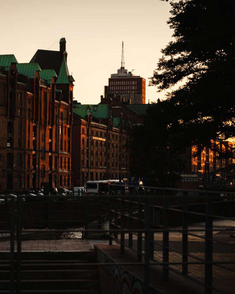 Historische Backstein-Lagerhäuser der Speicherstadt Hamburg mit dem beleuchteten Schriftzug von Miniatur Wunderland bei Sonnenuntergang