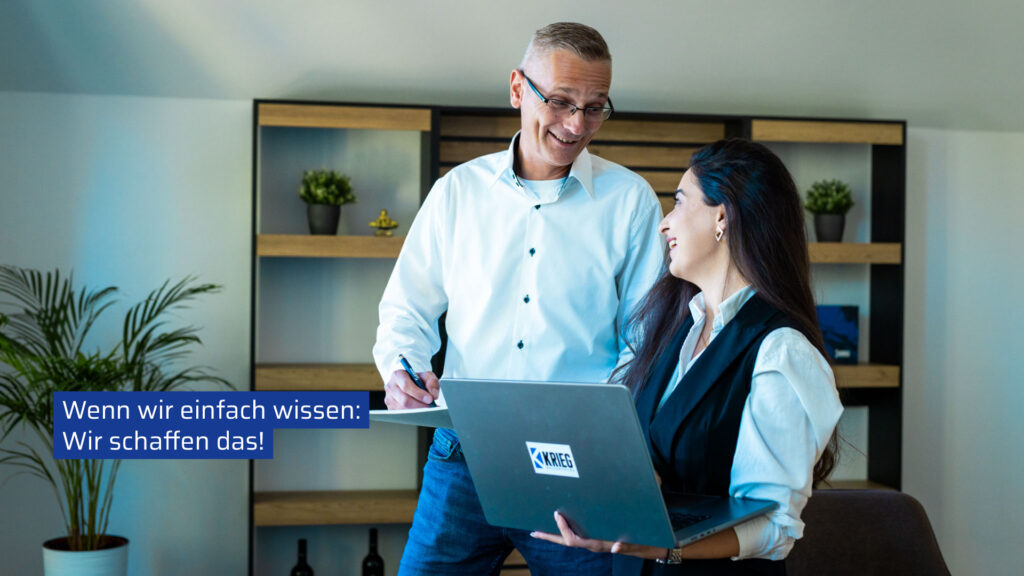 Zwei Kollegen im modernen Büro arbeiten motiviert zusammen, während eine Frau mit einem Laptop und ein Mann mit Unterlagen lächelnd kommunizieren.